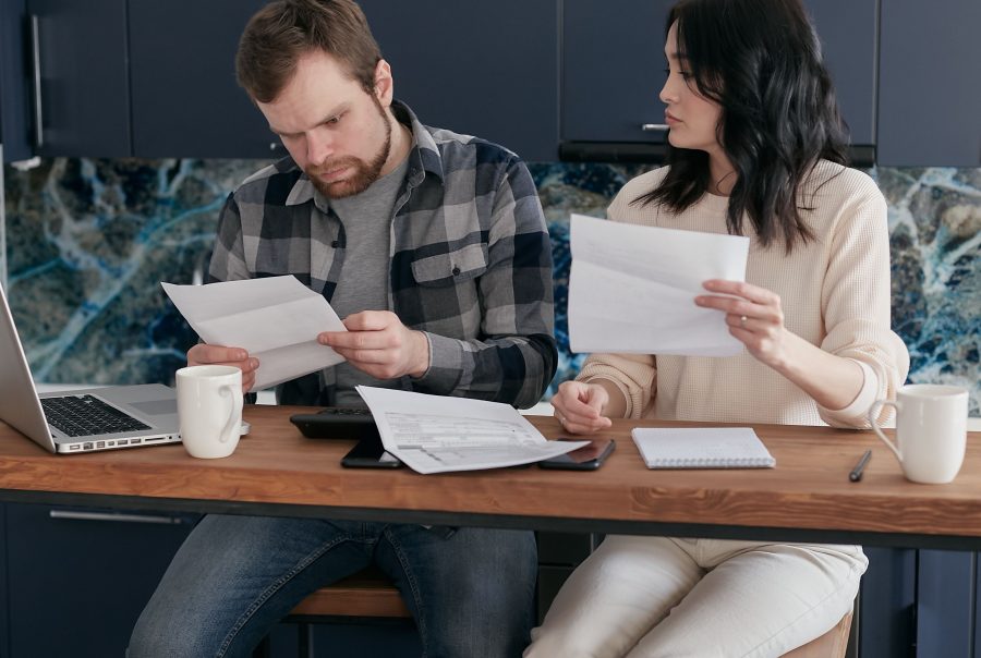 Pareja preocupada revisando y al comparar tarifas de luz en casa para ahorrar en su factura